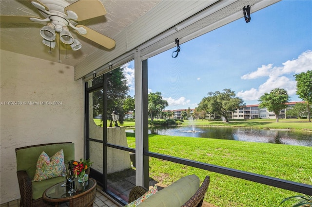 sunroom featuring a water view and ceiling fan