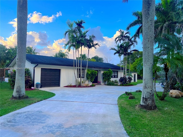 ranch-style house with a garage and a yard