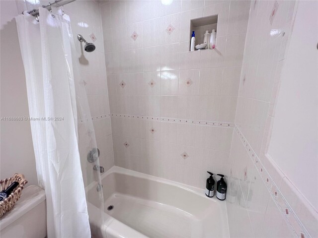 bathroom with shower / bath combo and toilet