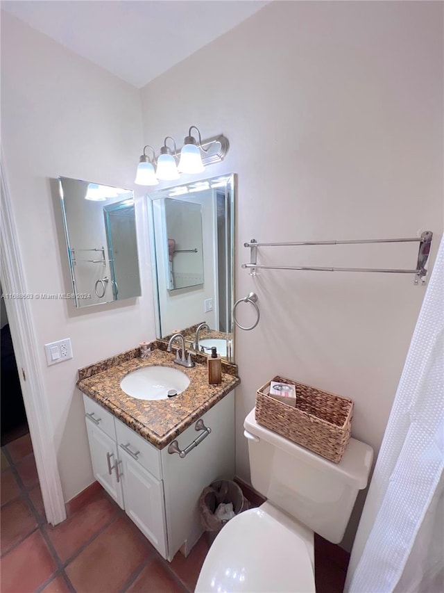 bathroom with tile patterned flooring, vanity, and toilet