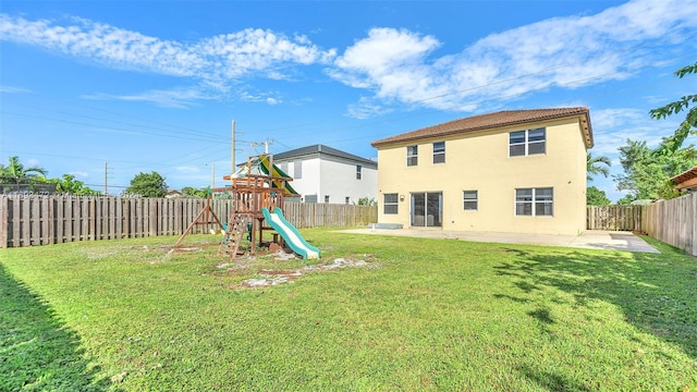 back of property with a playground, a patio area, and a lawn