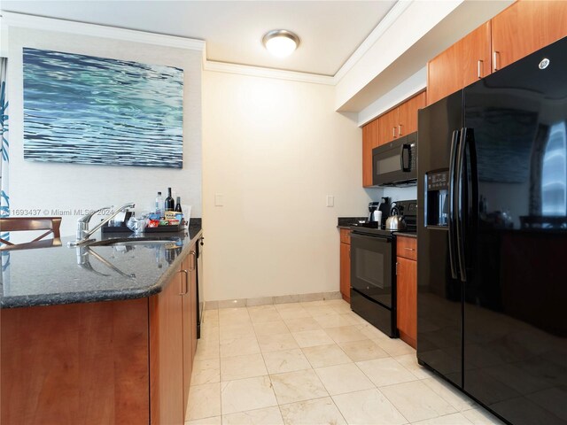 kitchen with black appliances, ornamental molding, sink, and dark stone countertops