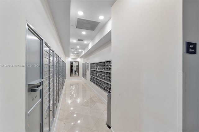 hallway featuring a mail area and light tile patterned flooring