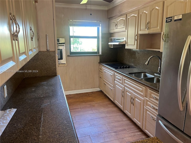 kitchen with sink, crown molding, stainless steel fridge, black electric cooktop, and exhaust hood