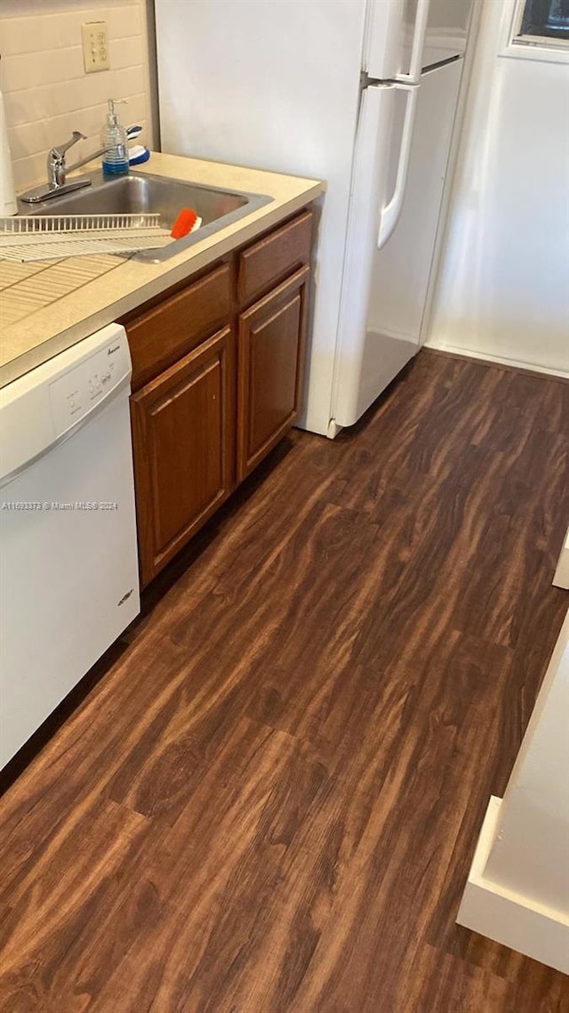 kitchen featuring dishwasher, tasteful backsplash, dark hardwood / wood-style flooring, and sink