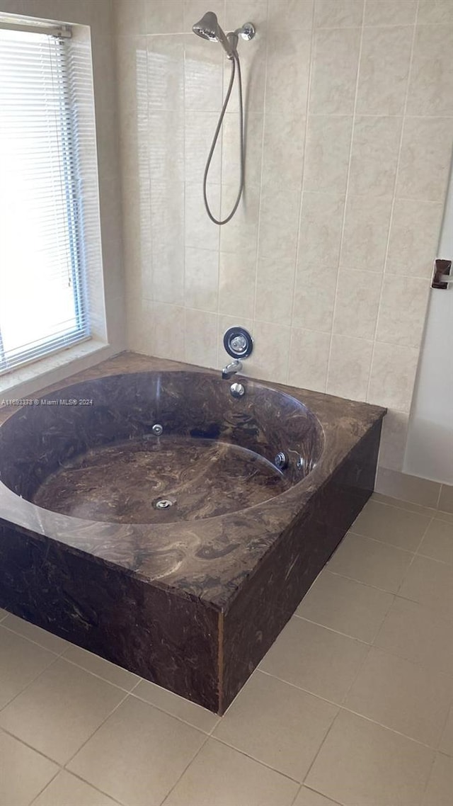 bathroom with tile patterned flooring and tiled shower