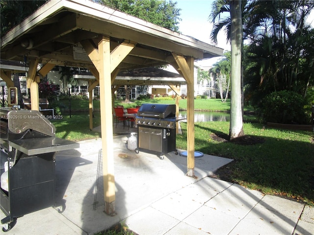 view of patio / terrace with a gazebo, area for grilling, and a water view