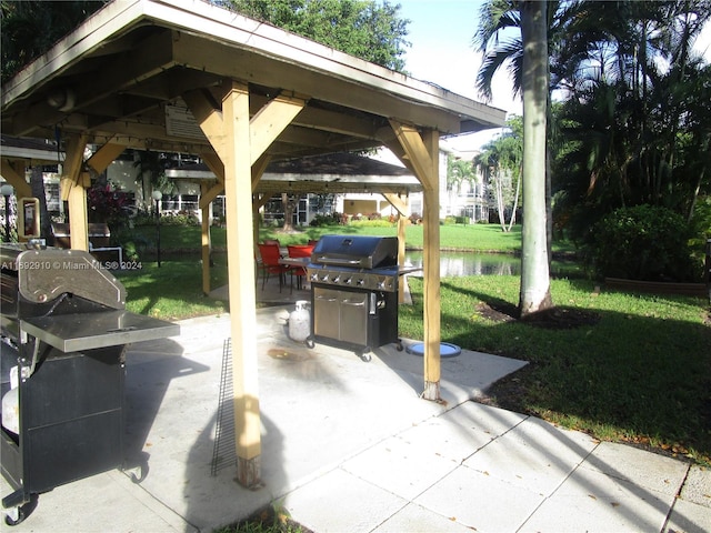 view of patio / terrace featuring a gazebo, a water view, and a grill