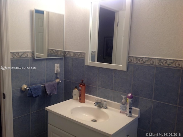 bathroom with vanity and tile walls