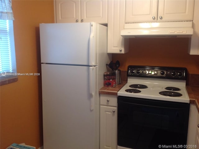 kitchen featuring white appliances and white cabinetry