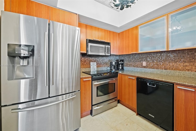 kitchen with light stone countertops, light tile patterned floors, decorative backsplash, and appliances with stainless steel finishes