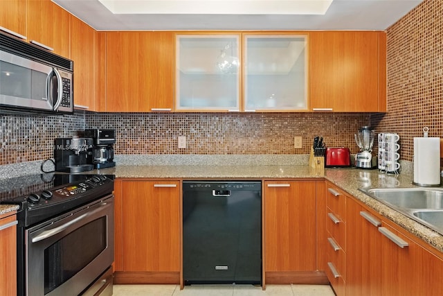 kitchen featuring light stone countertops, backsplash, and appliances with stainless steel finishes