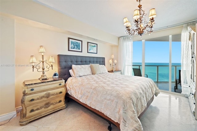 bedroom featuring an inviting chandelier, access to exterior, a water view, and a wall of windows