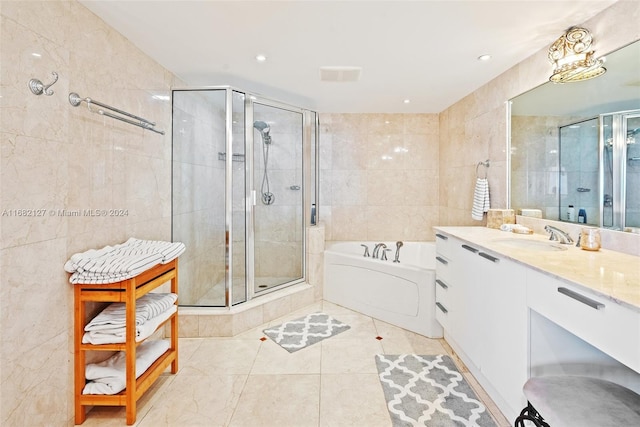 bathroom featuring vanity, independent shower and bath, and tile walls