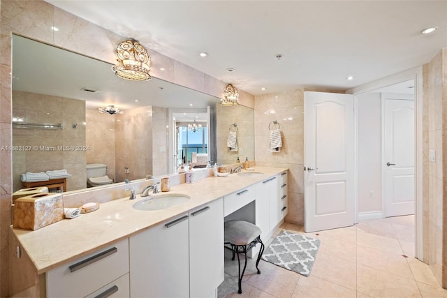 bathroom featuring toilet, tile walls, tile patterned flooring, a chandelier, and vanity