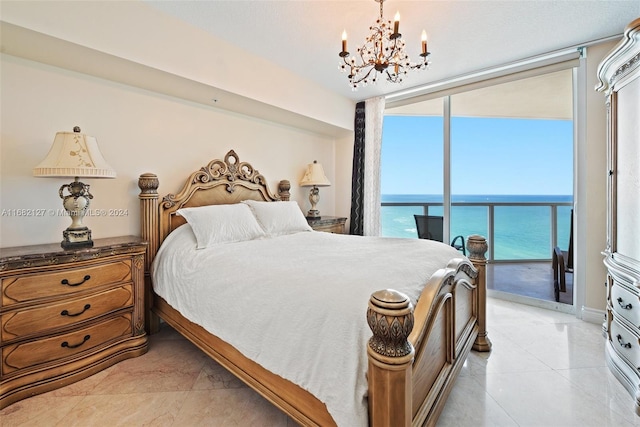 bedroom with an inviting chandelier, access to exterior, a water view, and a wall of windows