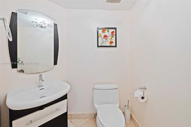 bathroom with toilet, vanity, and tile patterned floors