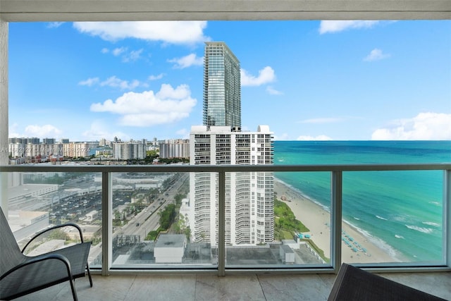 balcony featuring a view of the beach and a water view