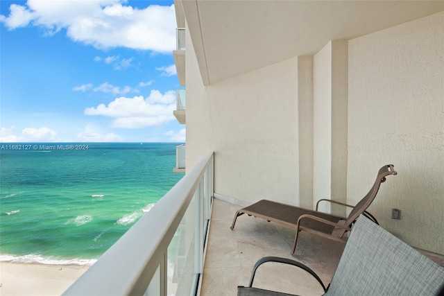 balcony featuring a water view and a view of the beach