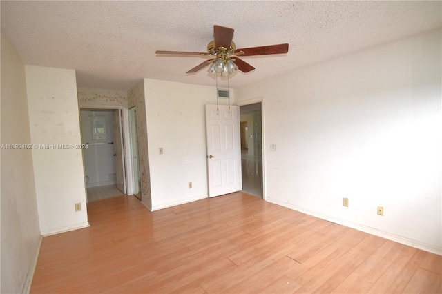 unfurnished room with ceiling fan, a textured ceiling, and light hardwood / wood-style floors