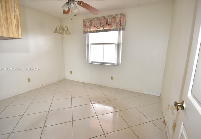 tiled empty room featuring ceiling fan