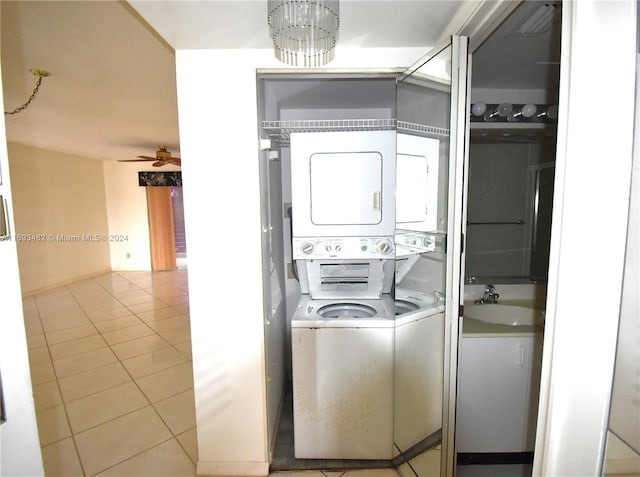 clothes washing area with ceiling fan, stacked washer and clothes dryer, light tile patterned floors, and sink