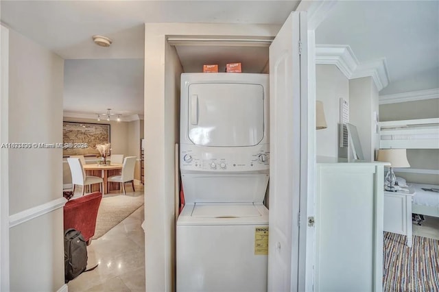 laundry room with ornamental molding and stacked washer and dryer