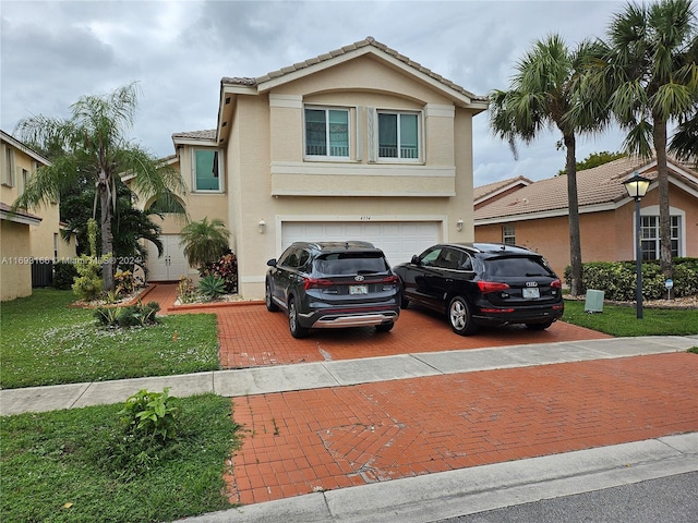 view of front of home featuring a front lawn, central air condition unit, and a garage