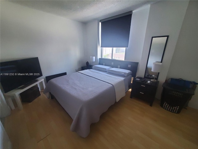 bedroom with light hardwood / wood-style flooring and a textured ceiling