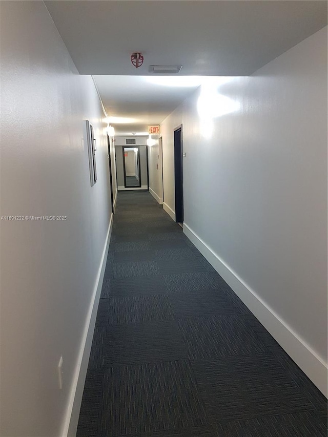 corridor featuring dark carpet