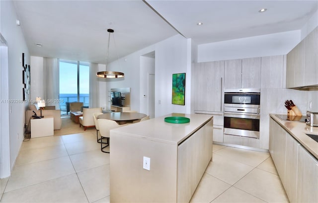 kitchen with light tile patterned floors, double oven, light countertops, modern cabinets, and decorative light fixtures