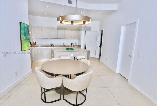 kitchen with light tile patterned floors, baseboards, modern cabinets, decorative light fixtures, and light countertops