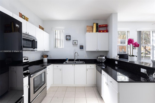 kitchen featuring light tile patterned flooring, stainless steel appliances, white cabinetry, and sink