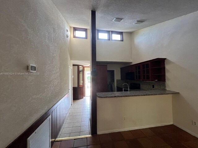 tiled empty room featuring a textured ceiling and ceiling fan