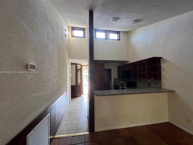 kitchen with a high ceiling, sink, and a textured ceiling