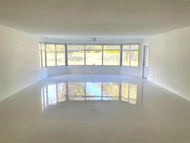 tiled empty room featuring ceiling fan