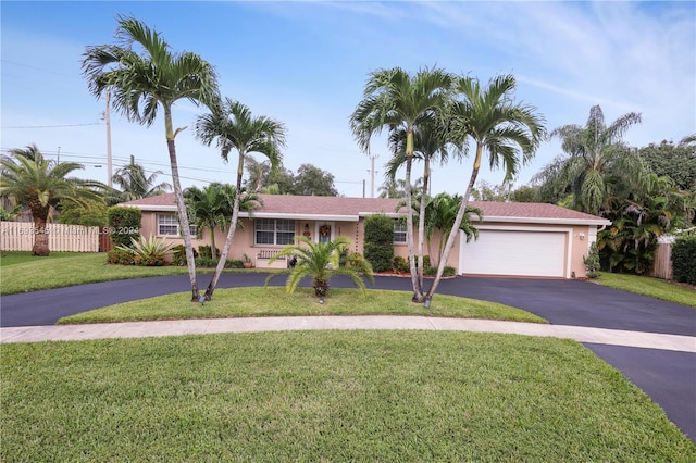 ranch-style home featuring a garage and a front lawn