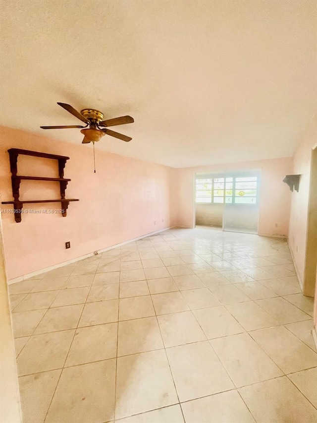 spare room featuring light tile patterned floors, lofted ceiling, a ceiling fan, and baseboards