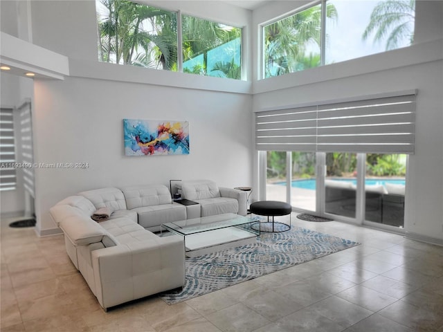 living room featuring light tile patterned floors and a high ceiling