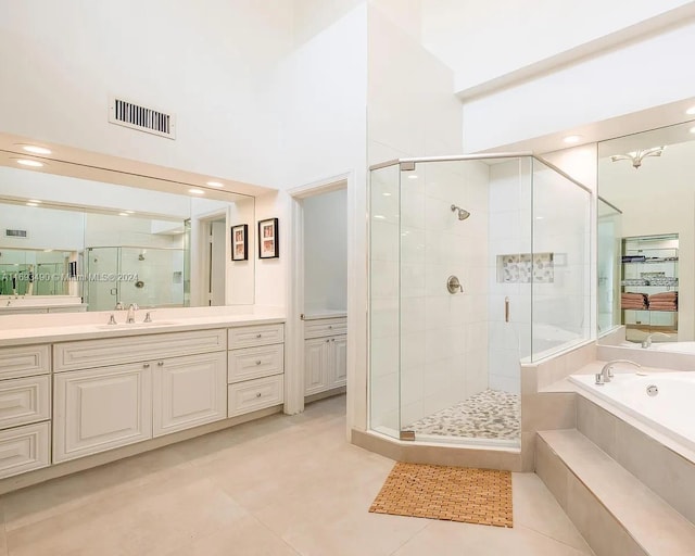 bathroom with a towering ceiling, vanity, tile patterned floors, and independent shower and bath