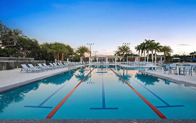 pool at dusk with a patio