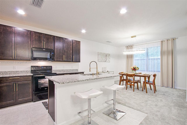 kitchen with black appliances, a kitchen breakfast bar, a center island with sink, sink, and light colored carpet