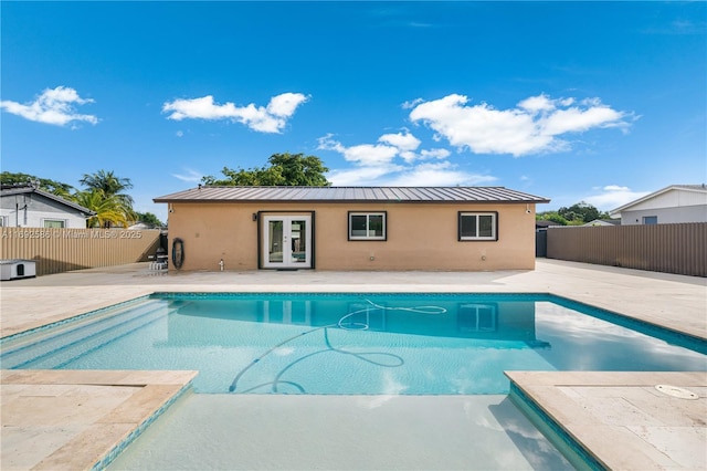 view of swimming pool featuring a patio area, a fenced backyard, a fenced in pool, and french doors