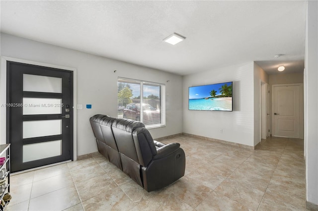 living area with baseboards and a textured ceiling