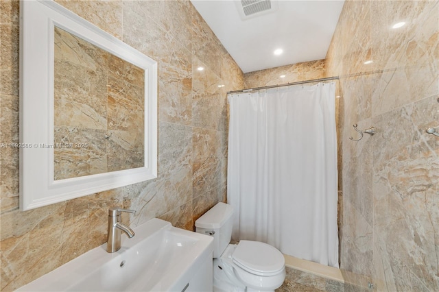 full bath with visible vents, toilet, a shower with curtain, vanity, and tile walls