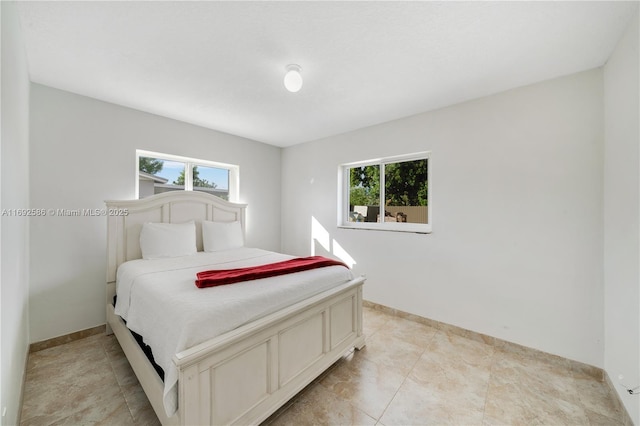 bedroom featuring multiple windows and baseboards