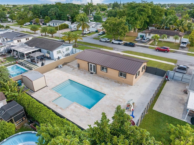 view of pool with a patio, a fenced backyard, and a residential view