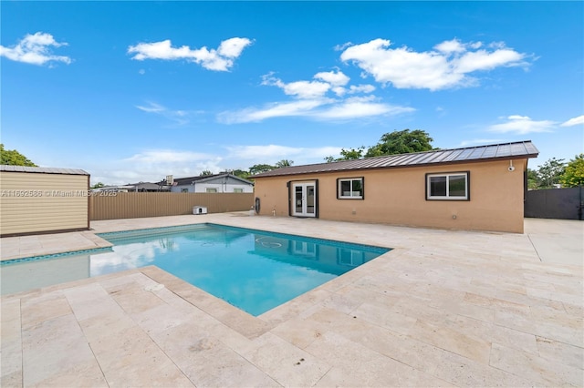 view of swimming pool with french doors, a patio area, a fenced backyard, and a fenced in pool