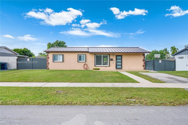 ranch-style home with a standing seam roof, fence, a front lawn, and stucco siding