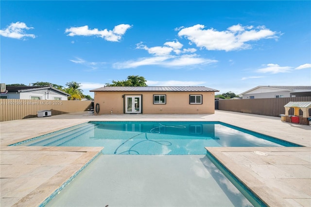 view of pool with a patio area, a fenced backyard, a fenced in pool, and french doors